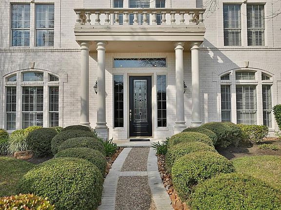 SOLID WOOD AND LEAD GLASS FRONT DOOR - A close up view of the custom 8 foot wood and lead glass door with decorative transom window and side panels. Loads of light enter making the entrance to the home light and bright. Notice the wall of brick from 