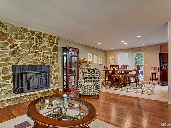 Bright living room with beautiful wood floors and fire burning fireplace