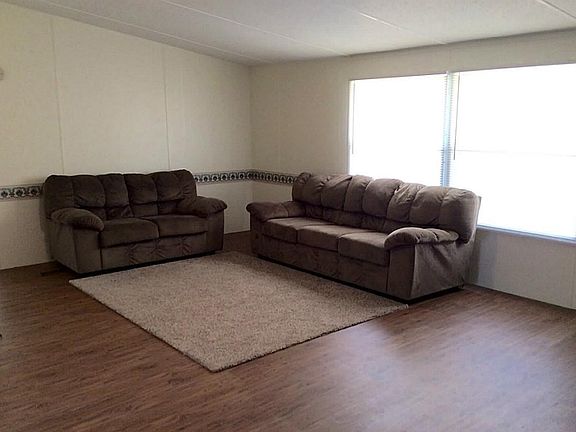 Spacious and bright living room features recent flooring, paint and window covering.