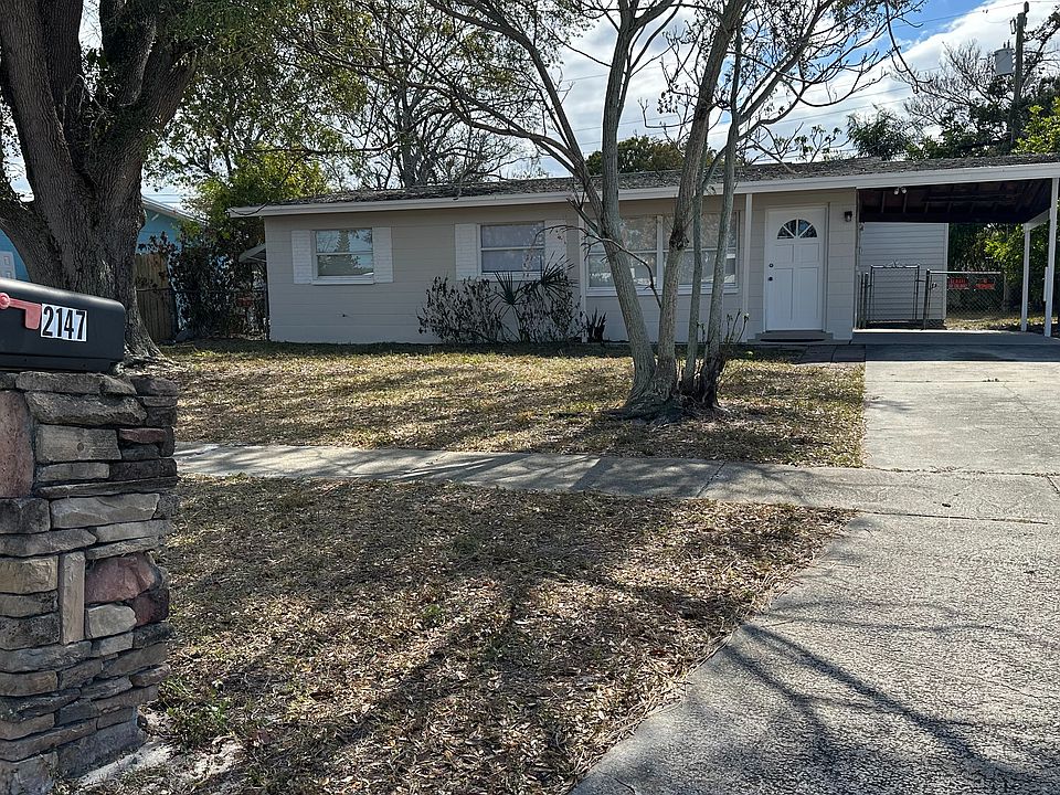 Street view with sidewalks, generous driveway and covered parking.