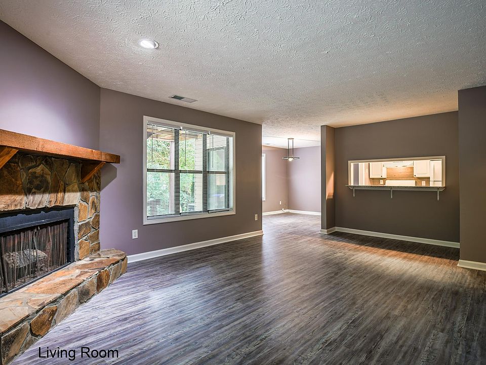 As you enter the apartment, a spacious living room with a fireplace and natural light greet you. The pass through from the kitchen is a convenient place to drop your packages .