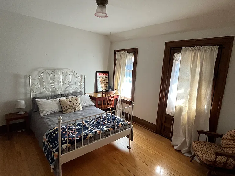 Back bedroom with full size bed, desk, dresser, reading nook, two closets, and outdoor patio