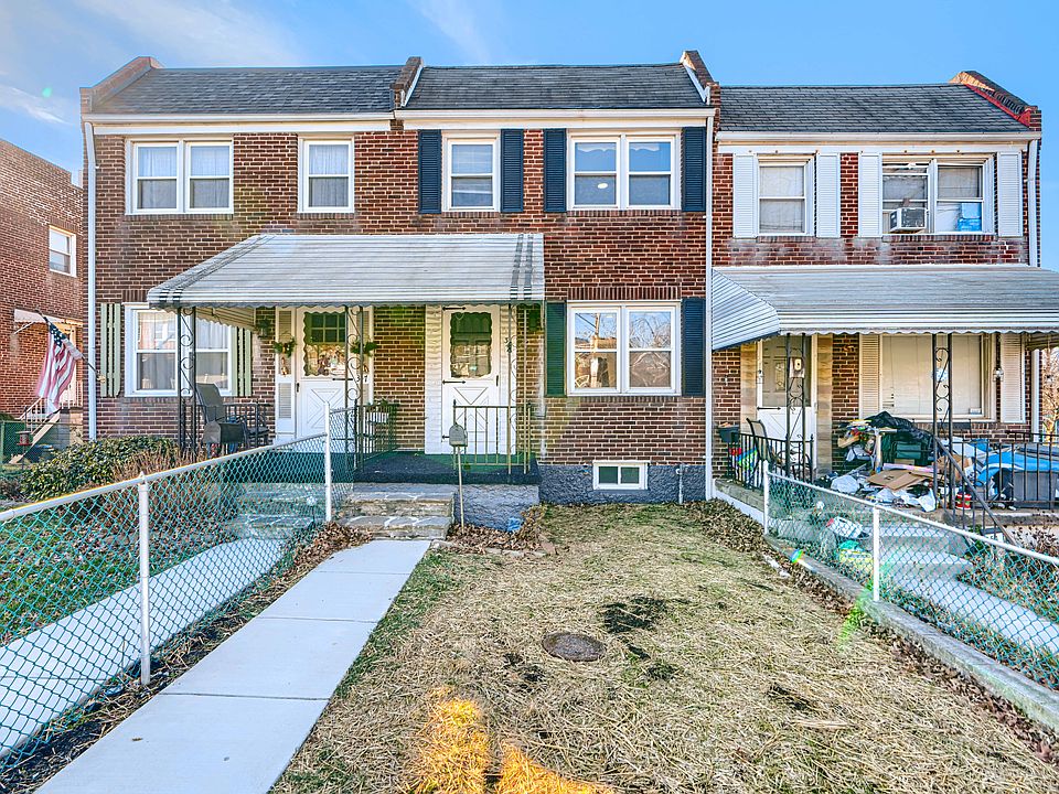 The house as seen from the front with a freshly seeded fenced in front yard.