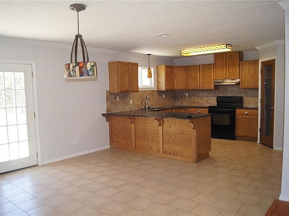 Open kitchen with counter dining, tons of cabinetry, walk in pantry, tile floors and French door to back of property and open patio.