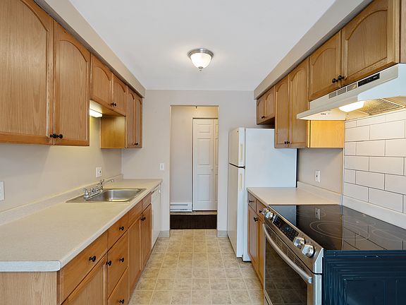 Opposite the foyer we find the galley kitchen with ample cabinet space and lots of room for food prep on the counters running along both sides of the room.