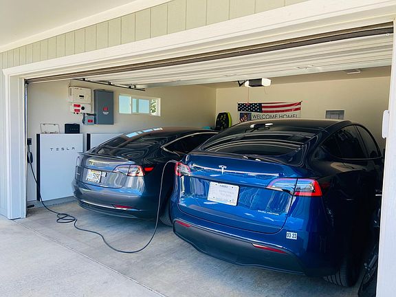 Spacious garage can hold 2 vehicles. Tesla Powerwalls store solar energy to aid powering home, even at night.