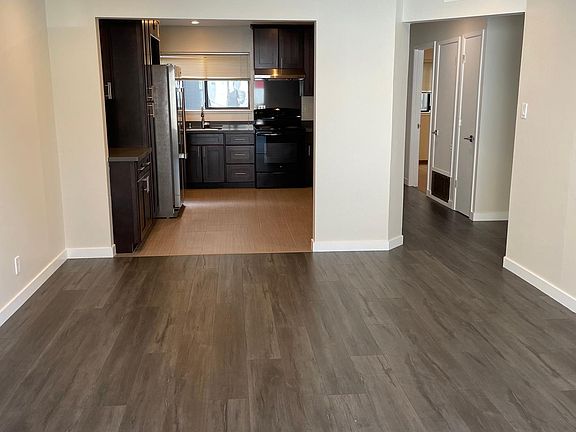 View from living room into kitchen. New flooring in living room and entry