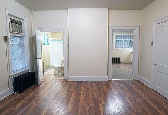 Looking in from front room looking at what is typically living room, bathroom on left and Kitchen on right