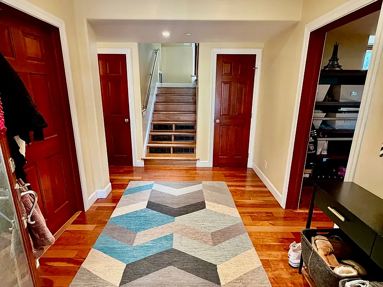 Entry hall. To the left: small office/bedroom and full bathroom with washer and dryer, plus access to 2 car garage. To the right: access to large bedroom (last tenant used as family room).
