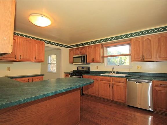 The spacious kitchen has significant cabinet and counter space. The peninsula island counter has overhang that serves as an info