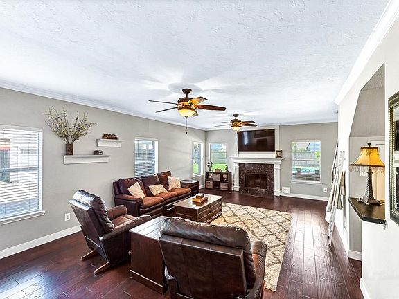Living room features wood flooring and gas log fireplace.