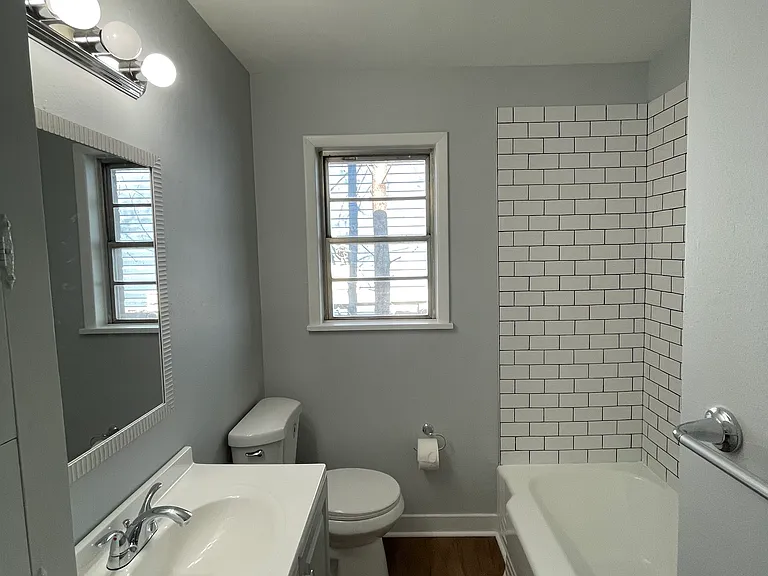Updated bathroom. New toilet, sink, and tile work around the shower-tub combo.