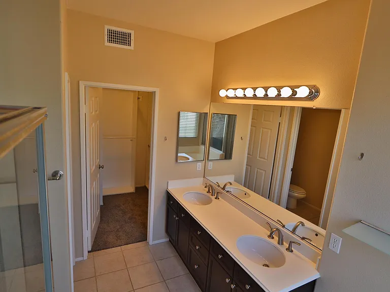 Double sink master bath with LED soft white bulbs. Door leads to master walk in closet. Master bath also has enclosed toilet.