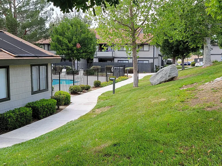Grassy walkway around office and pool area at Dove Ridge Apartments.