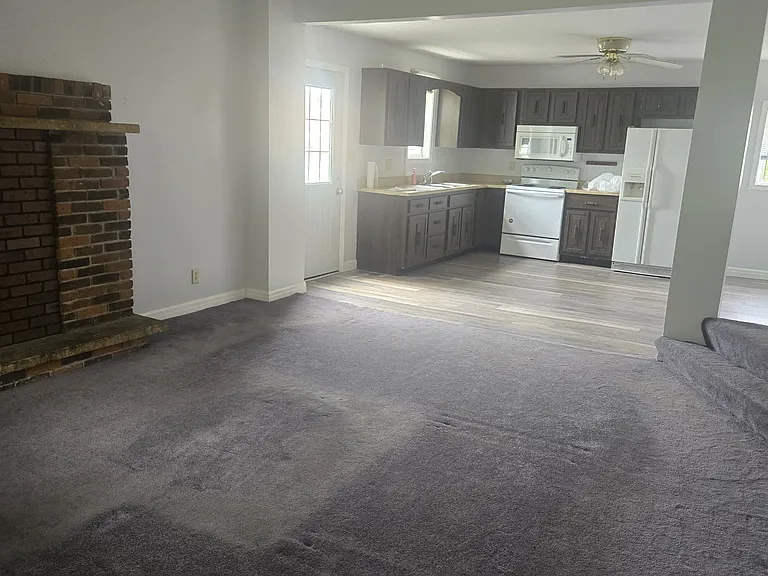 Open concept living room kitchen. Stove microwave and fridge included