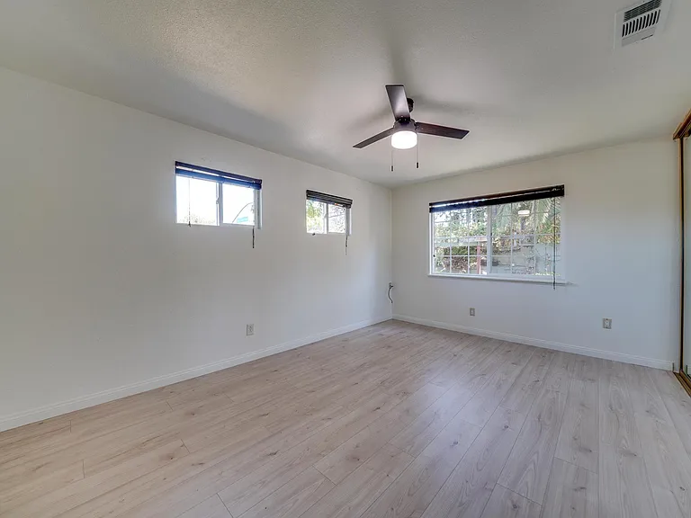 Master bed with new fan, pain, and flooring.