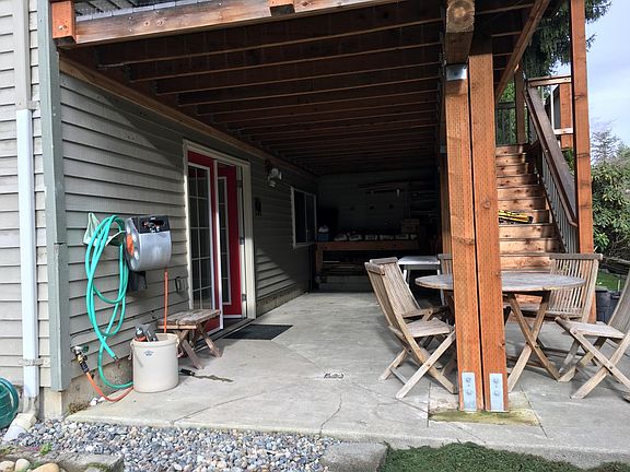 Nice dry patio for storage. Great spot for additional freezer or fridge. Staircase on right leads to possible shared middle level deck.