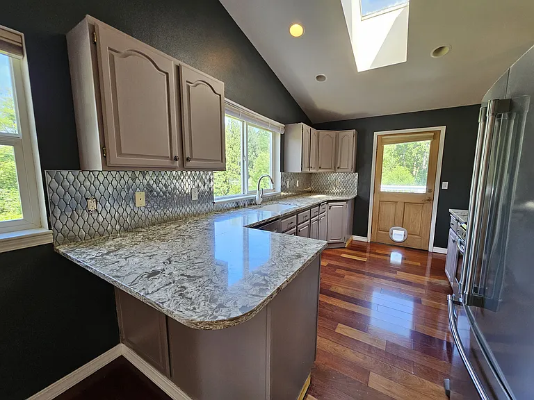 Updated kitchen with quartz counters, stainless steel appliances, gas range and a skylight!