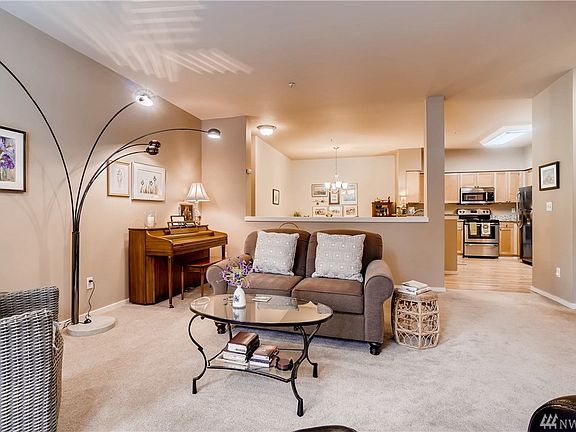 Spacious living room with gas fireplace, walls of windows, door leading to balcony and deck.