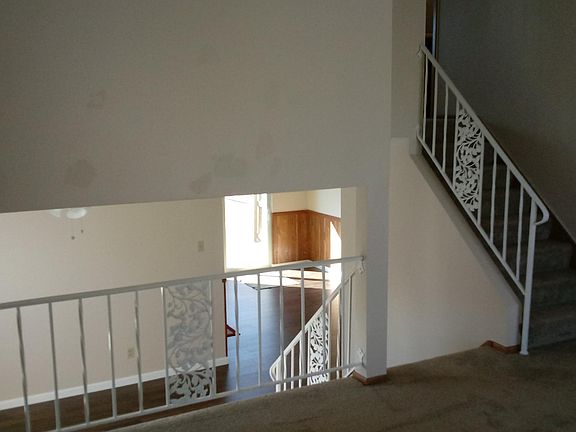 Living room with stairs to upper level on right and view loo