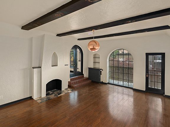 Spacious sunken living room with southern exposure and ample natural light. Balcony entrance, covered elevated balcony, overlooking South Lake Union and the Olympic Mountains, and sunsets.