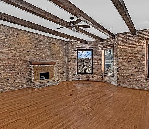 Exposed brick, large windows, tall ceilings and hardwood floors with gas fireplace
