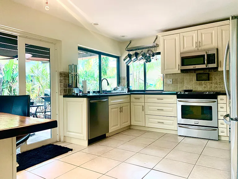 kitchen area with new stainless steel appliances large windows to view pool