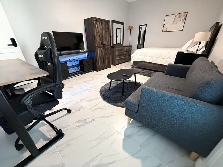 Large bedroom suite with Queen bed, sofa, mini-fridge, ample storage with wardrobe closet & dresser. Electric rising desk