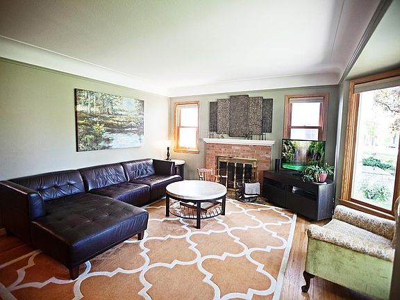 The welcoming living room is flooded with light and beautiful bay windows.