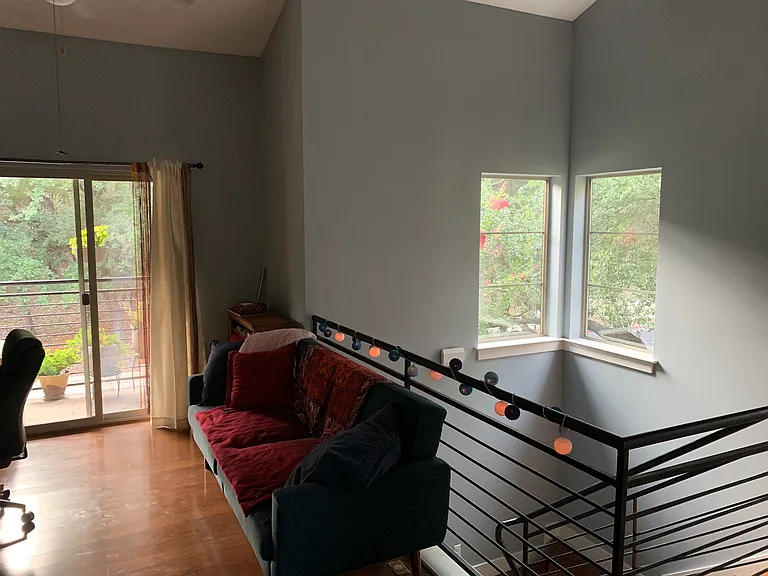 Loft area with full size futon sofa and office space with access to patio