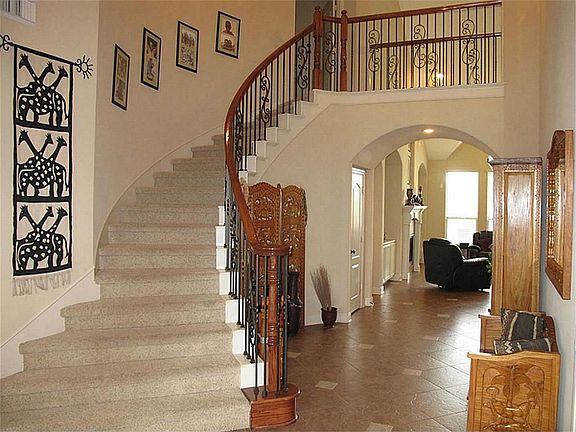 This winding staircase with BEAUTIFUL decorative iron railings greets your guests upon entry!