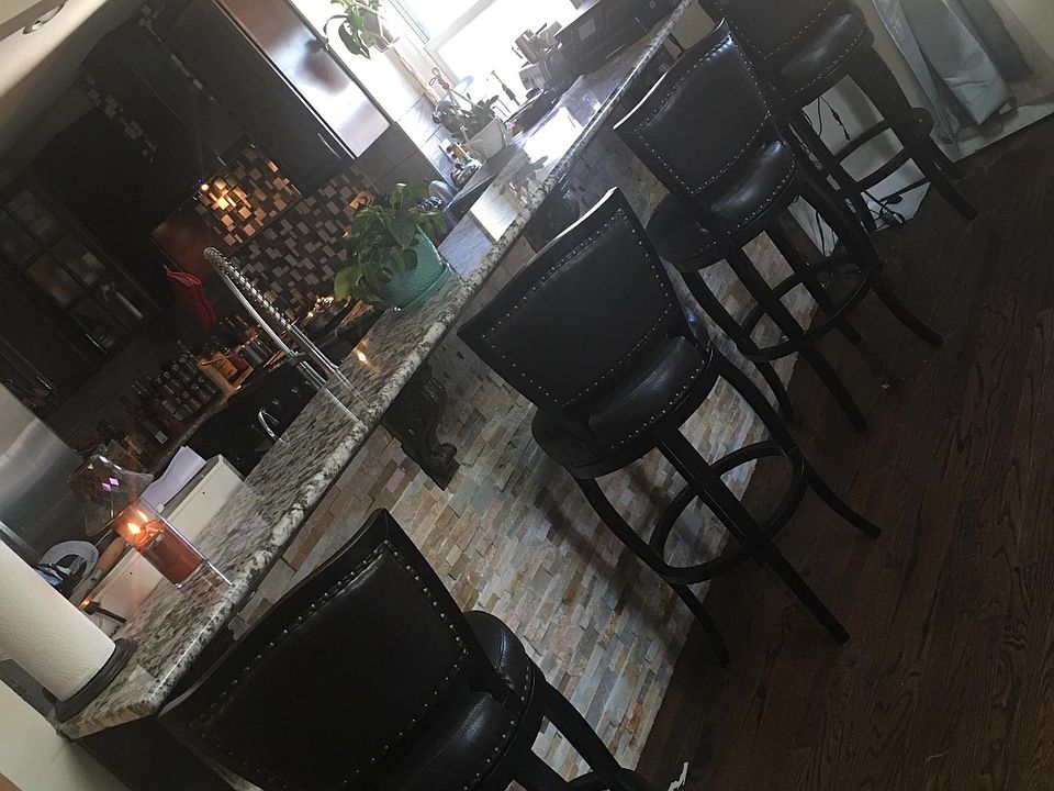 Stone breakfast bar open to kitchen and living room