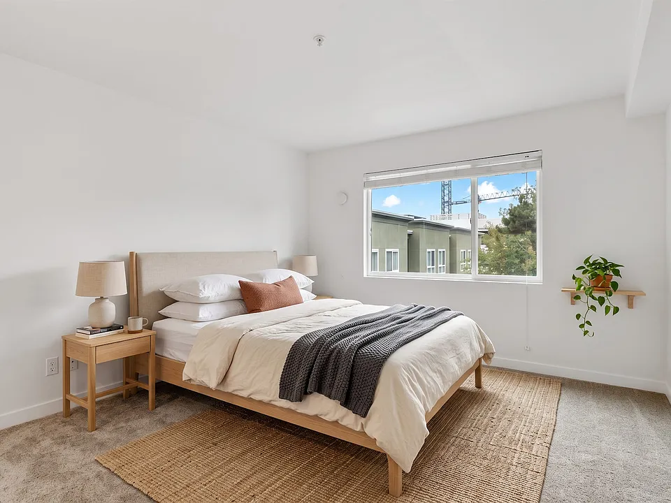 Room enough for a queen bed with clear space on both sides, under a window that catches the morning light.