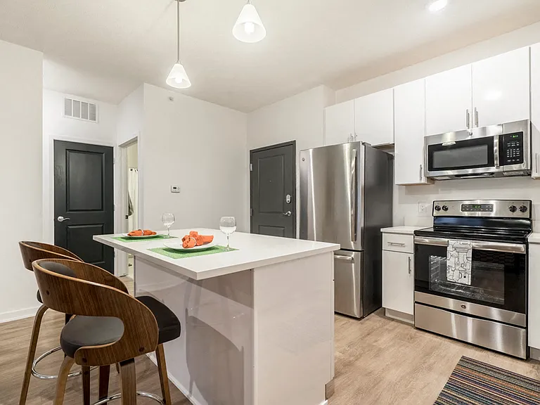 Our contemporary kitchens feature white cabinetry, white quartz countertops and stainless-steel appliances.