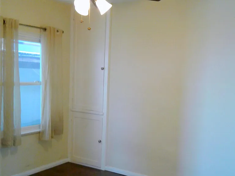 Bedroom with two large windows and big deep cabinets for lin