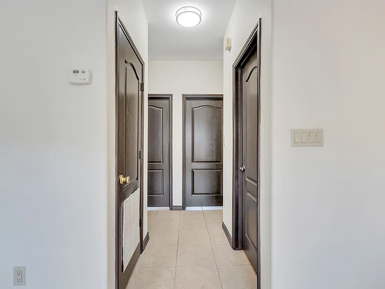 Sophisticated hallway in Merida Vista Apartments, adorned with two doors and a modern light fixture enhancing the ambiance