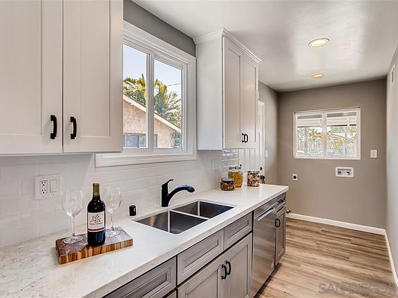 Quartz counter top, subway tile back-splash, under-mounted stainless steel sink.
