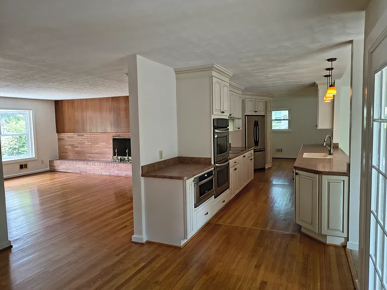 The kitchen hosts stainless-steel appliances, all electric, including a microwave, double oven, refrigerator, and two-drawer dish washer.