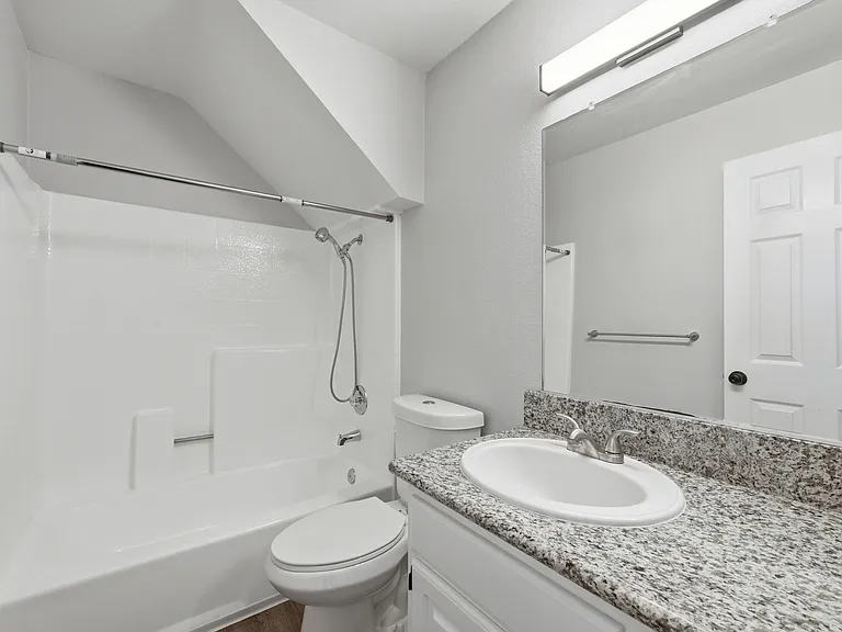 A white bathroom with a toilet, sink, and bathtub.