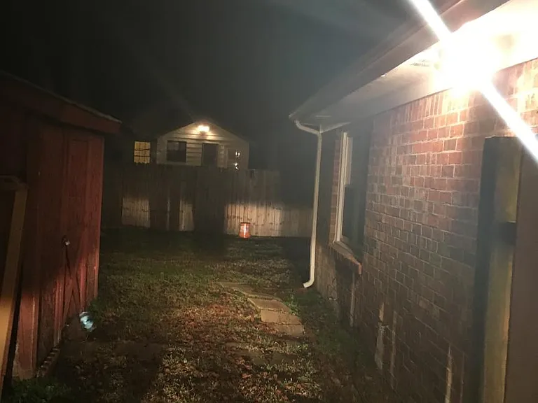 Side of house showing security lights and shed