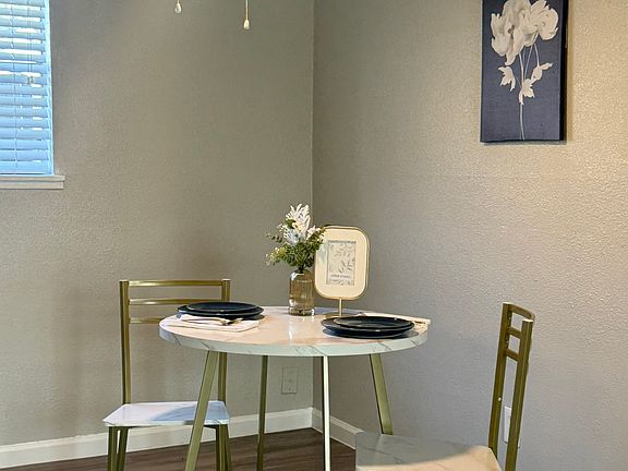 This inviting dining area features warm natural light and a contemporary ceiling fan that enhances the clean, updated design.