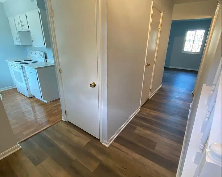 Kitchen to the left. Nearest door is a coat closet, further door is the ground floor powder room.