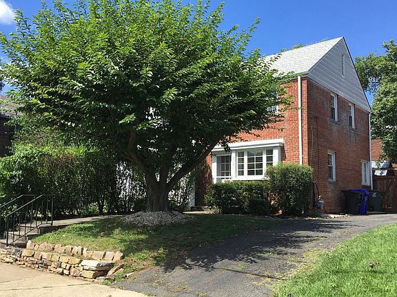 Front yard with cherry tree and driveway on the side of the building.
