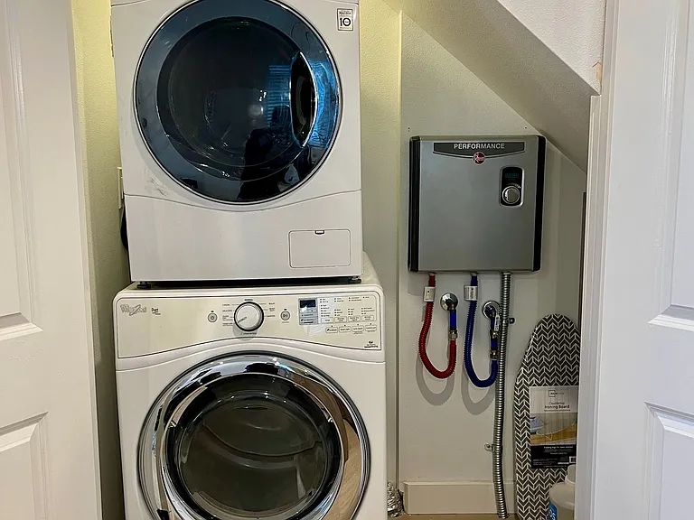 Streamlined living: Our laundry room offers the perfect blend of functionality, with a washer, dryer, and a smartly stored ironing board at your fingertips.