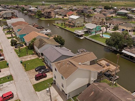 An Aerial view for the front of the home to the canal and the great deck at the back of the home.