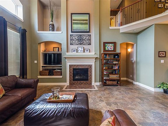 A second view of the family room with gas log fireplace that has tile surround, mosaic border and a 