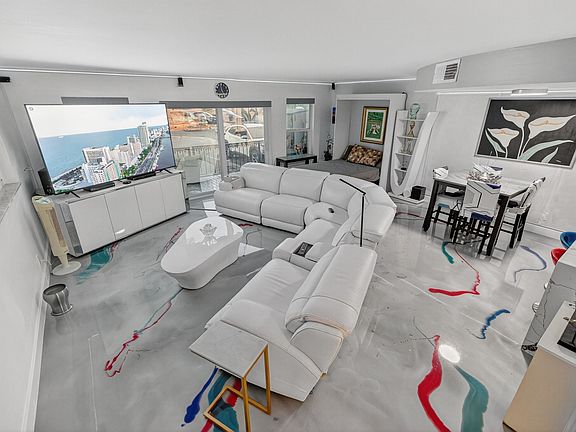 view of whole living/dining space coming down from staircase. Murphy bed open.