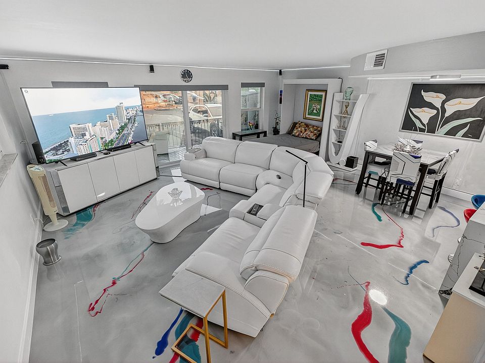 view of whole living/dining space coming down from staircase. Murphy bed open.