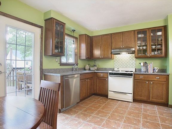 Large kitchen with granite counters, ceramic tile floors, french doors to deck