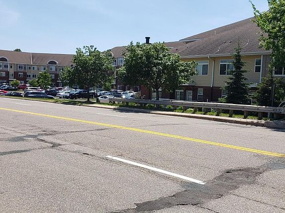 Cross street view shows sidewalk for convenient pedestrian travel to the shopping village